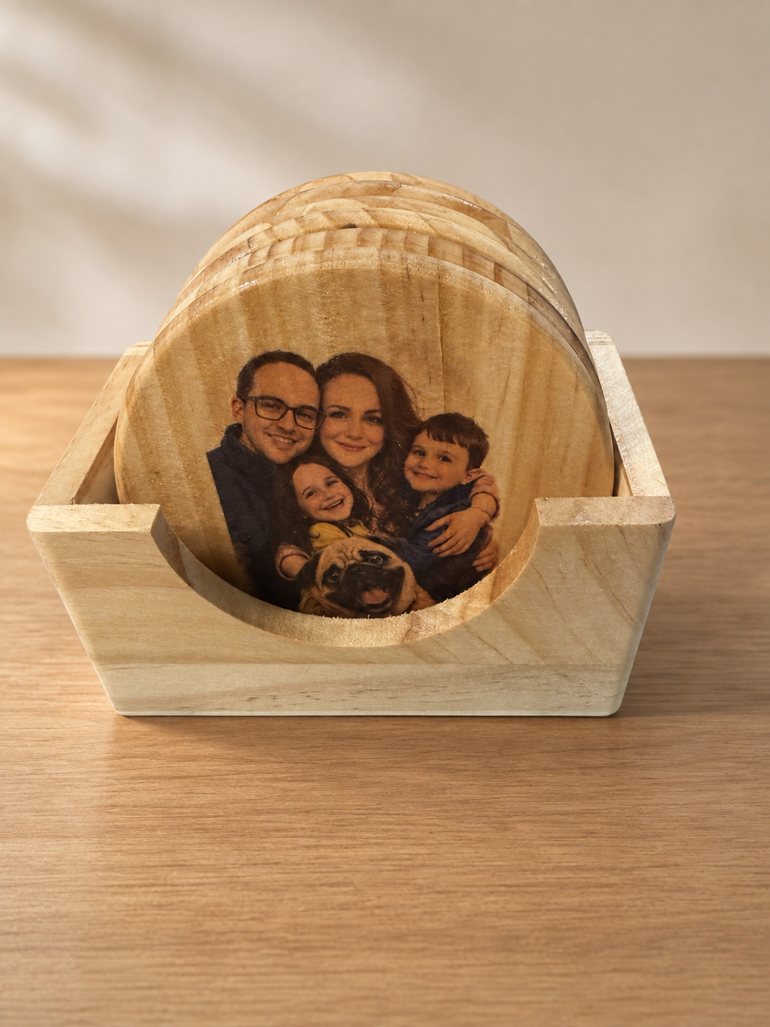 Clear-coated family photo coaster set in a wooden holder on a clean studio background
